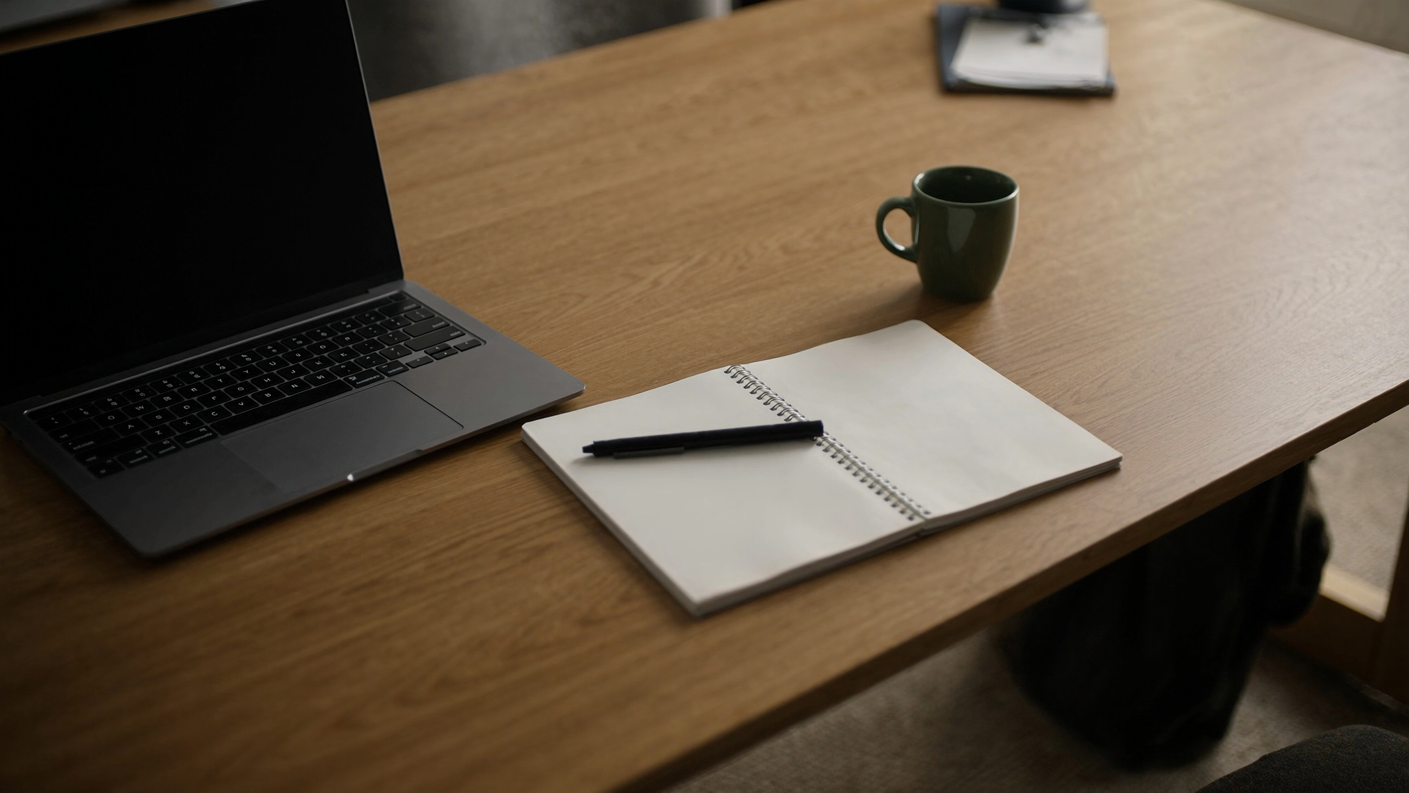 Desk with a laptop and notebook, representing evaluating AI front desk software for dental practices
