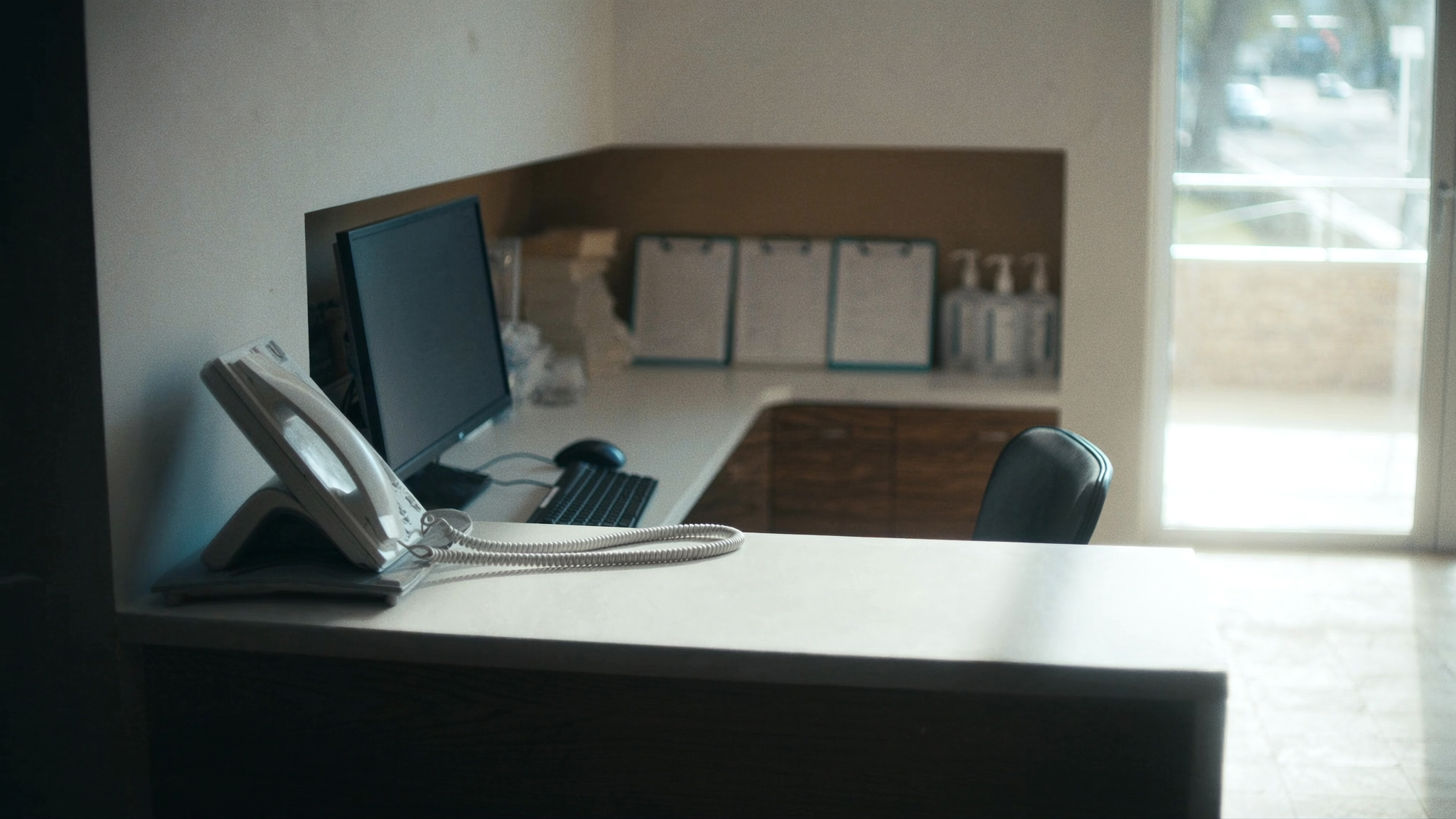 Empty dental practice reception desk in morning light, representing an AI receptionist for dentists