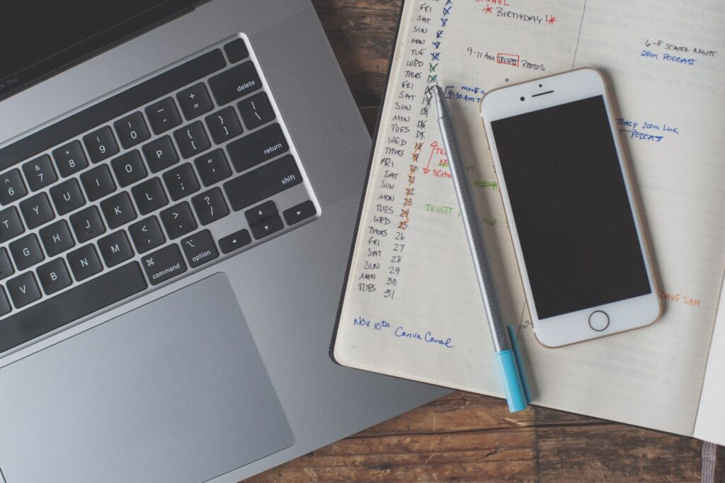 A smartphone resting on an open notebook covered in handwriting.