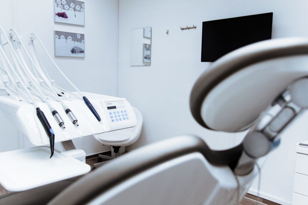 A bright, empty dental treatment room with the chair and instruments ready.
